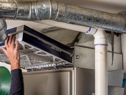 Man replaces a filter in a furnace
